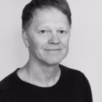Svart-hvitt portrettbilde av Kim Kristoffer Dysthe, kort hår, mørk t-skjorte, lys bakgrunn