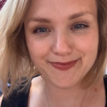 Profilbilde Hedda Barvik, blondt hår, rød leppestift, mørk skjorte.
