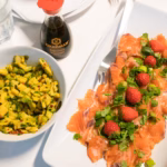 Bilde fra matlagingsseanse i CARBFUNC-studien. Tallerken med laks, grønt og jordbær, samt en skål med mangosalsa. Ved siden av står en kikkoman soyasaus. Foto:Amanda I. O. Andersen.